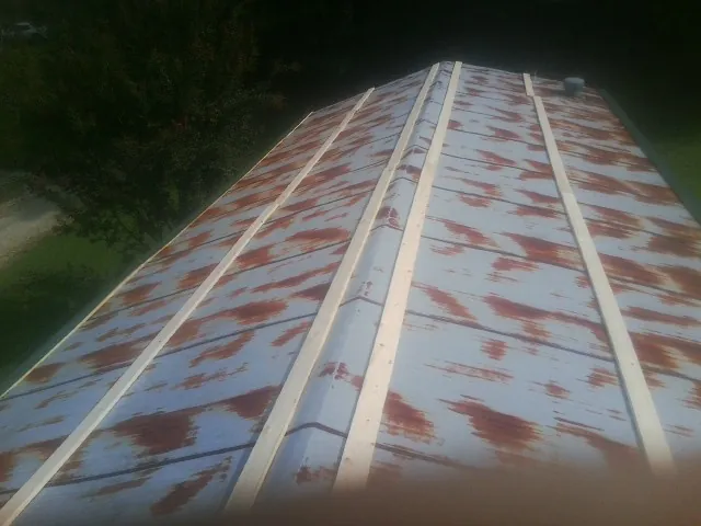 Rusted metal roof panels with new wood purlins before replacement — Storm Damage Roof Repair in Mathews by Roofing Brothers