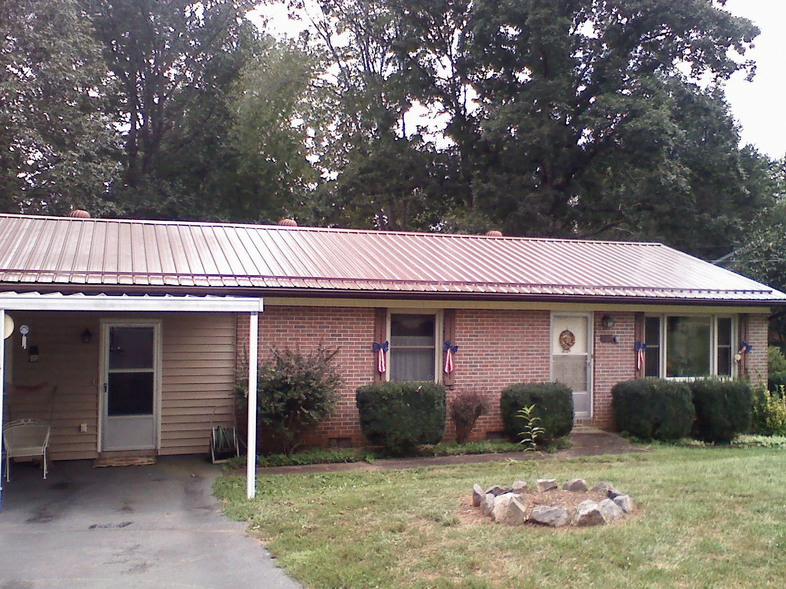 Bronze metal roof and carport on a brick ranch home — Roof Repair work by our crew in Mathews