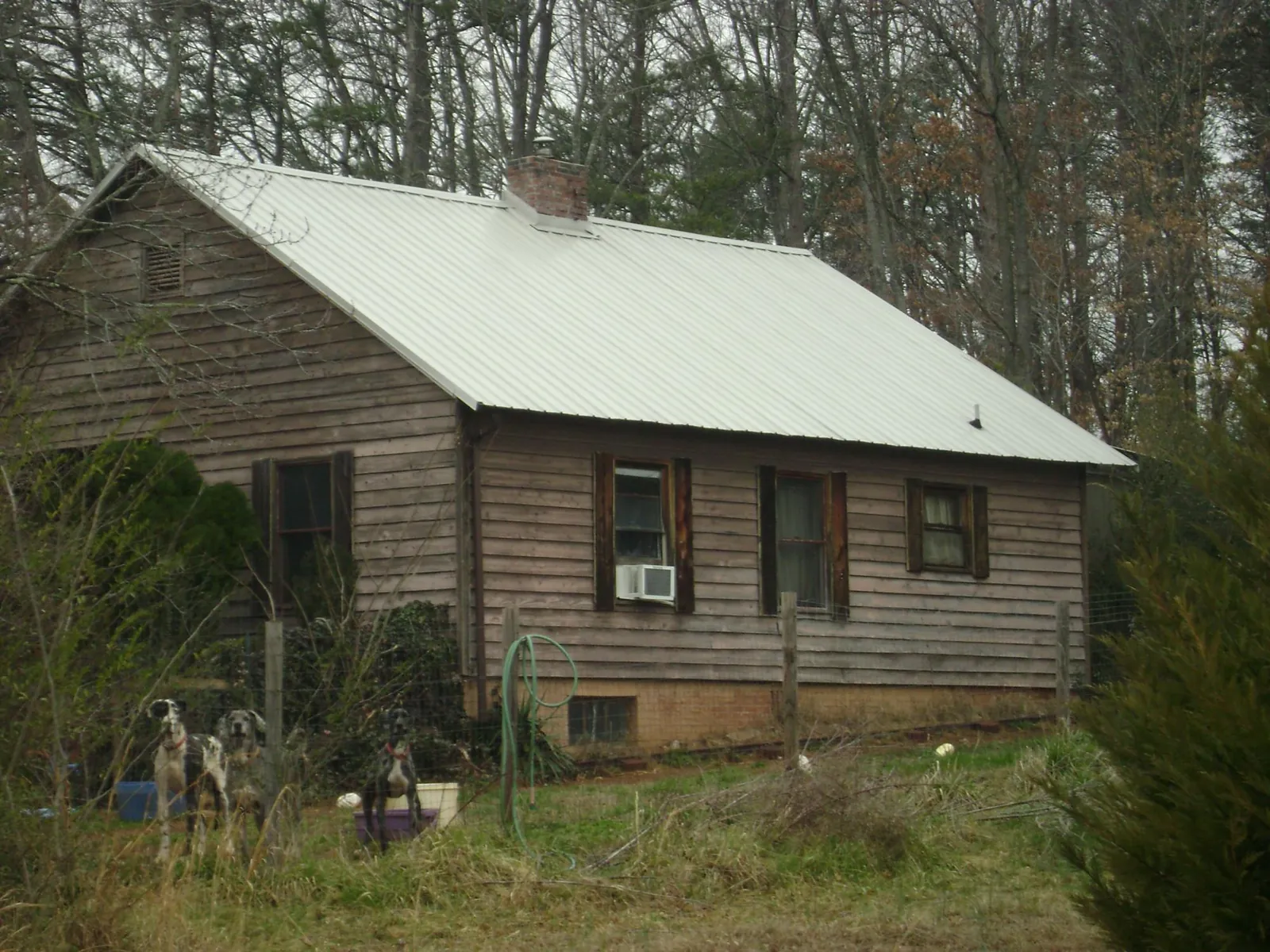 White metal roof on an old wood sided farmhouse, from a Metal Roof Installation job in Mathews